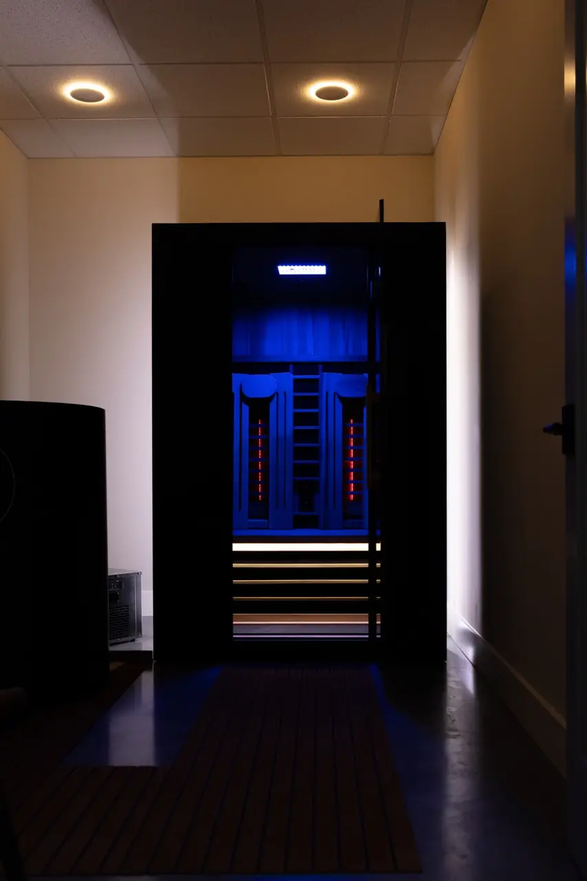 The infrared sauna glowing blue inside its private suite